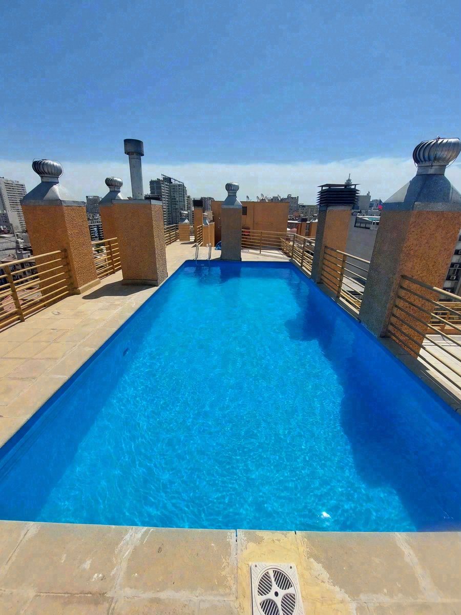 Piscina en azotea de edificio con vista panorámica a Santiago