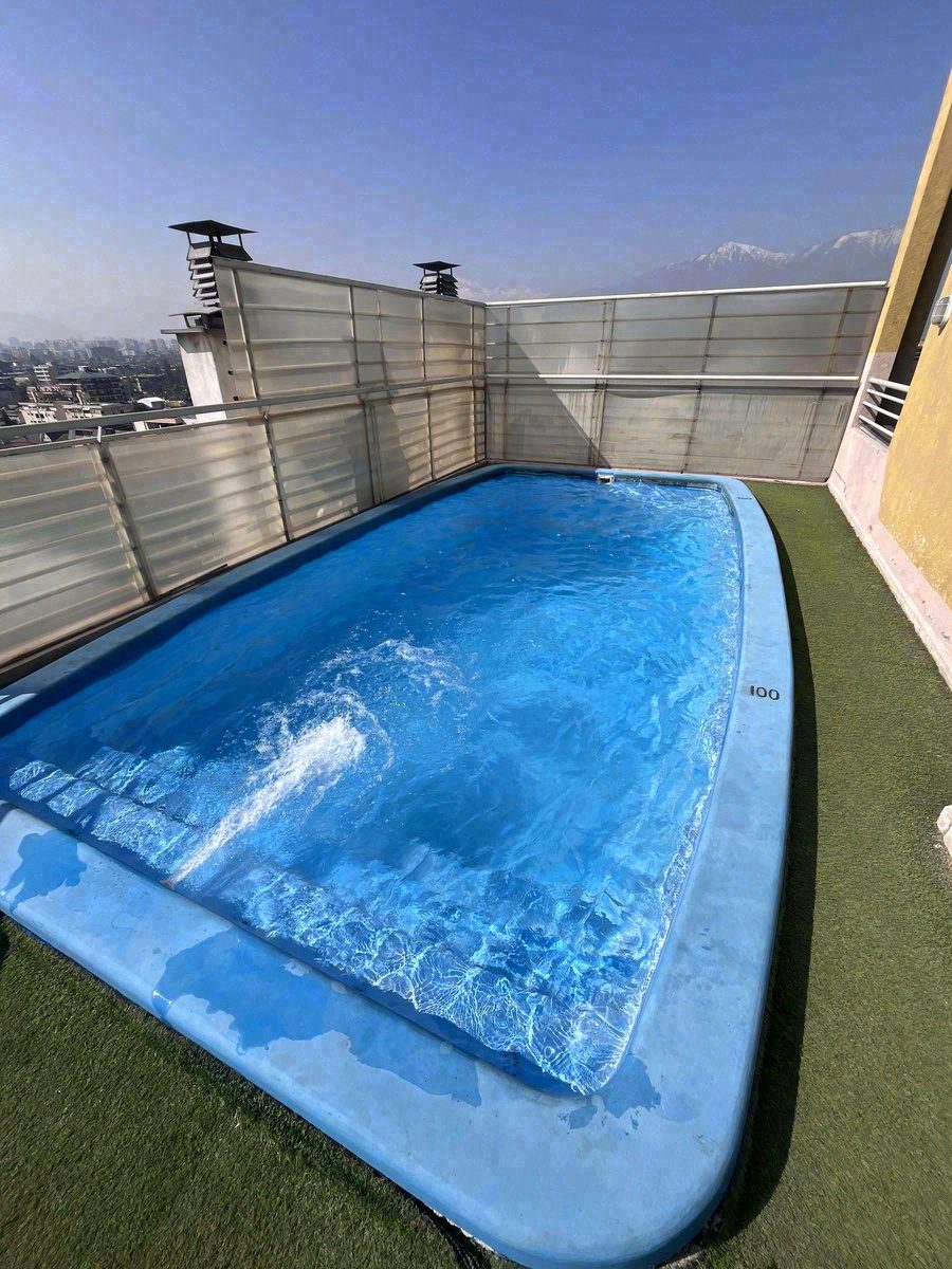 Piscina en azotea de edificio con vista a la cordillera de los Andes