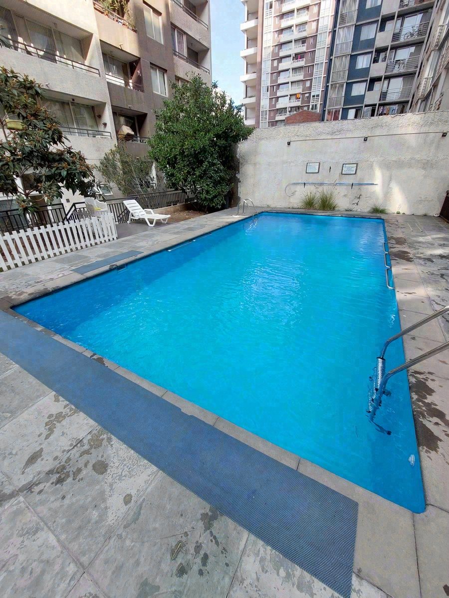 Piscina de condominio en patio interior con solárium