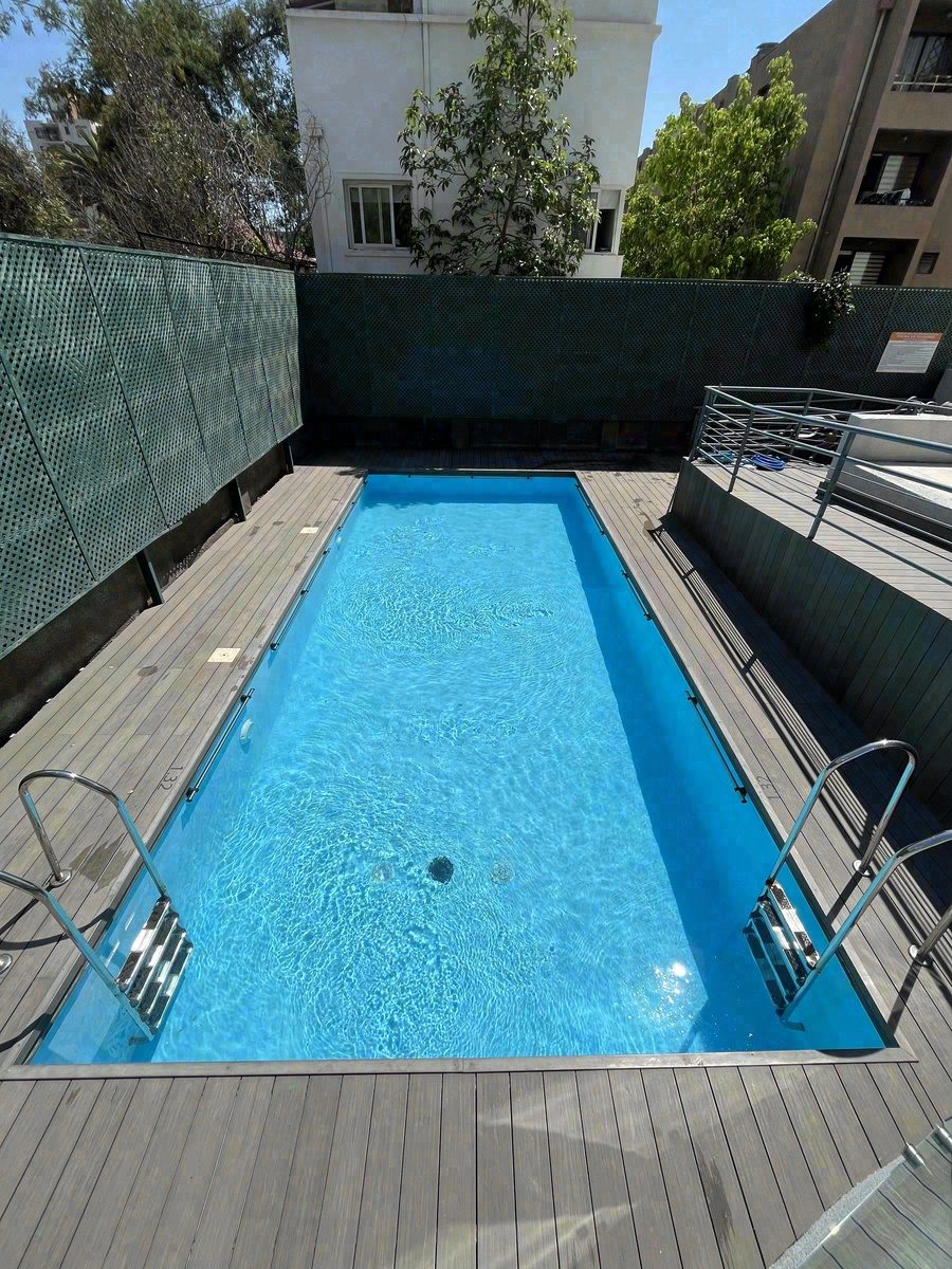 Piscina de condominio con deck de madera