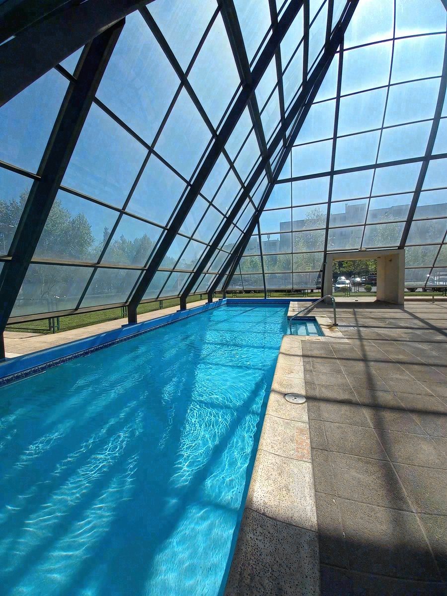 Piscina temperada de edificio bajo cúpula de vidrio