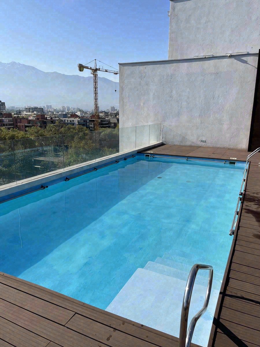 Piscina en azotea con deck de madera y vista a los Andes
